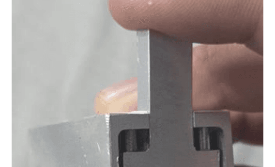 Dispositivo de aluminio con bisagra y botón de corte, sostenido con una mano